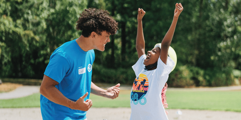 bike-instructor-cheering-on-a-camper-with-their-hands-in-the-air